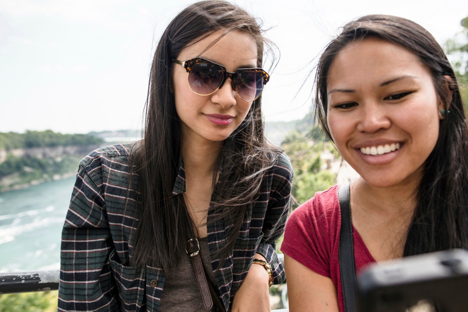 Two friends capturing memories with a scenic backdrop Two friends capturing memories with a scenic backdrop