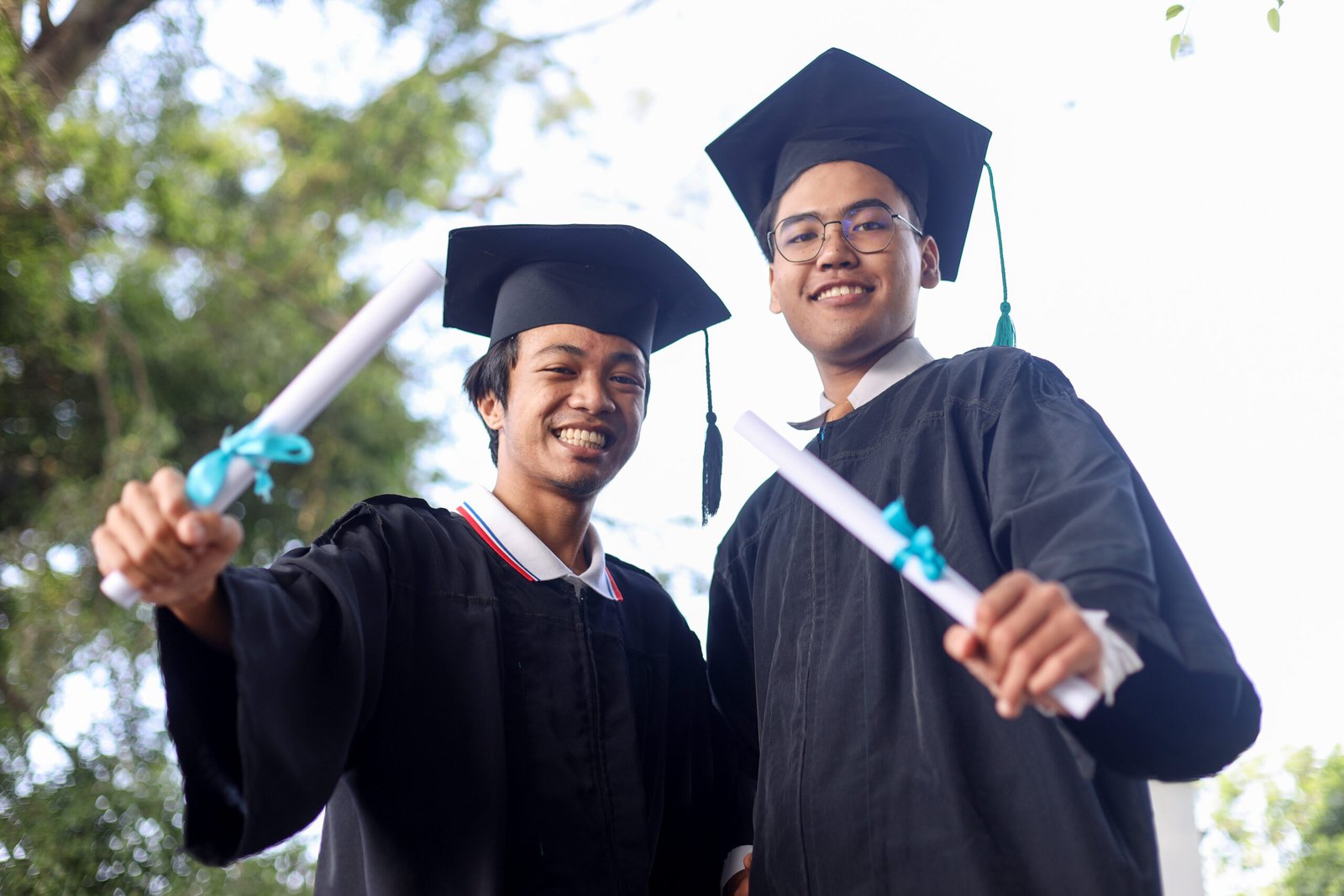 two-young-asian-college-graduates-holding-diplomas-2023-11-27-04-50-53-utc two-young-asian-college-graduates-holding-diplomas-2023-11-27-04-50-53-utc